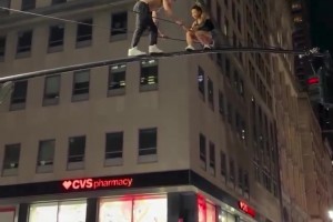 一对纽约的情侣爬上红绿灯杆接吻，庆祝尼克斯夺冠！